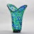 Found in the US, this circa 1990 tall art glass vase has a wide, flared neck and blue green splatter pattern with accents...