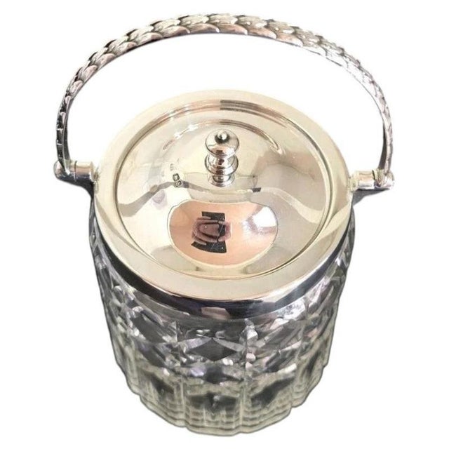A fine George V cut glass biscuit barrel dating to 1919, combining traditional English sterling silver craftsmanship with...