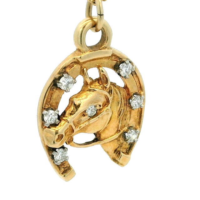 A beautifully detailed vintage equestrian pendant crafted in 14K yellow gold, featuring a sculpted horse head emerging...
