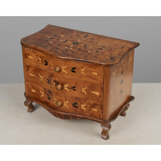 A French Louis XV style miniature commode, or sample chest. Hand-crafted of solid cherry with decorative mother of pearl...