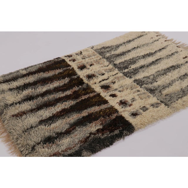 Hand-knotted in lush, high-pile wool in Sweden circa 1960-1970, this 4x6 vintage Swedish Rya rug is a bold new addition to...