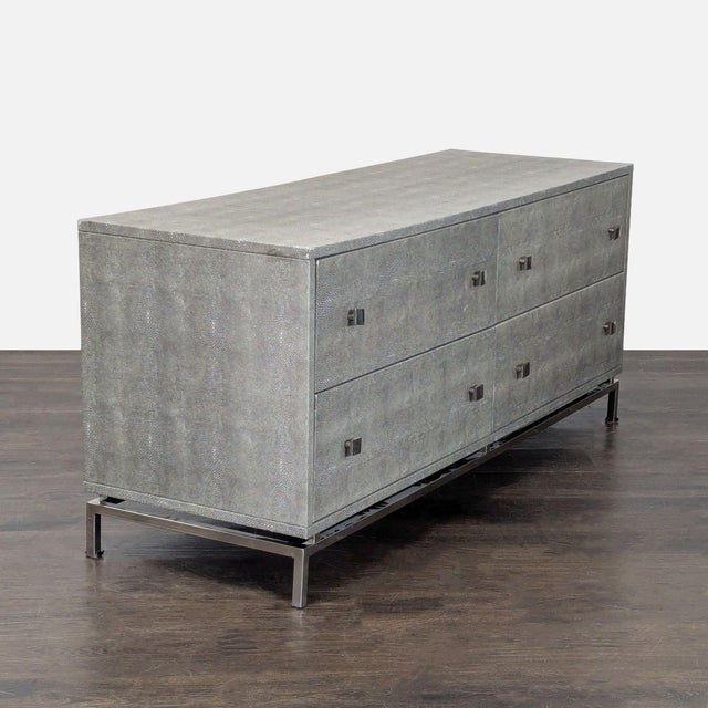 This CB2 dresser features a sleek grey finish and a contemporary metal base. It has four spacious drawers for easy storage...
