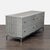 This CB2 dresser features a sleek grey finish and a contemporary metal base. It has four spacious drawers for easy storage...