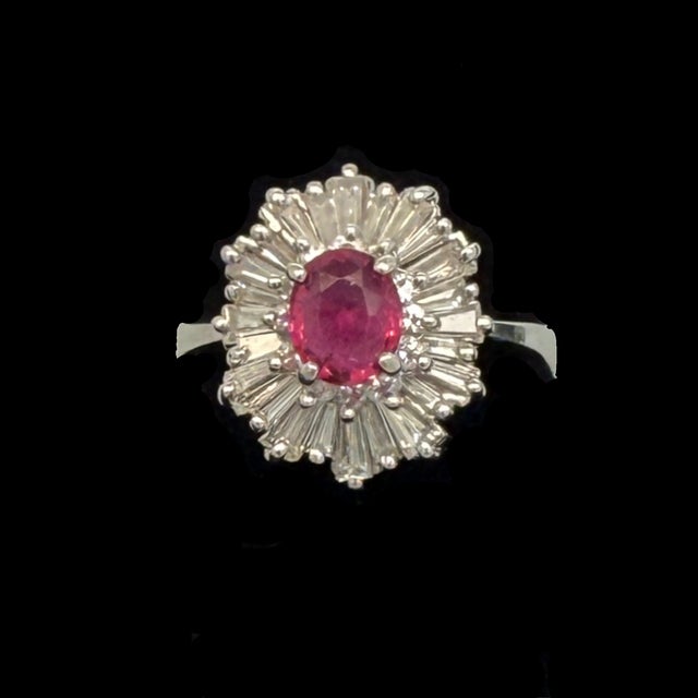 A jewel-toned centerpiece with real presence. A faceted oval ruby of approximately 1.8 carats sits at the heart of this...