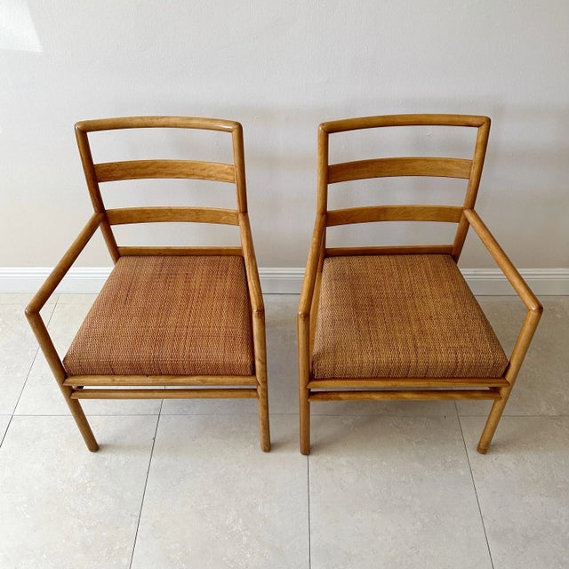 Pair of mid century armchairs by T. H. Robsjohn Gibbings for John Widdicomb. These chairs have light wooden frames,...
