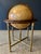 Combination brass and wood stand with a illuminated Heirloom globe by Replogle in the neo classical style. the stand is...