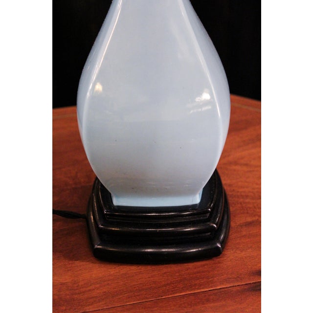 A Manises-made table lamp in light blue and black glazed ceramic. Its elegant shape and balanced proportions give it a...