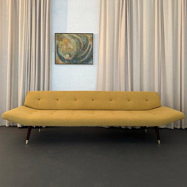 This long sleek Mid-century Modern gondola sofa daybed circa 1960s was made in the style of the American designer Adrian...