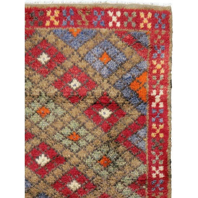 This mid-20th-century Turkish Anatolian throw rug presents a lively allover lattice of diamond-shaped compartments across...
