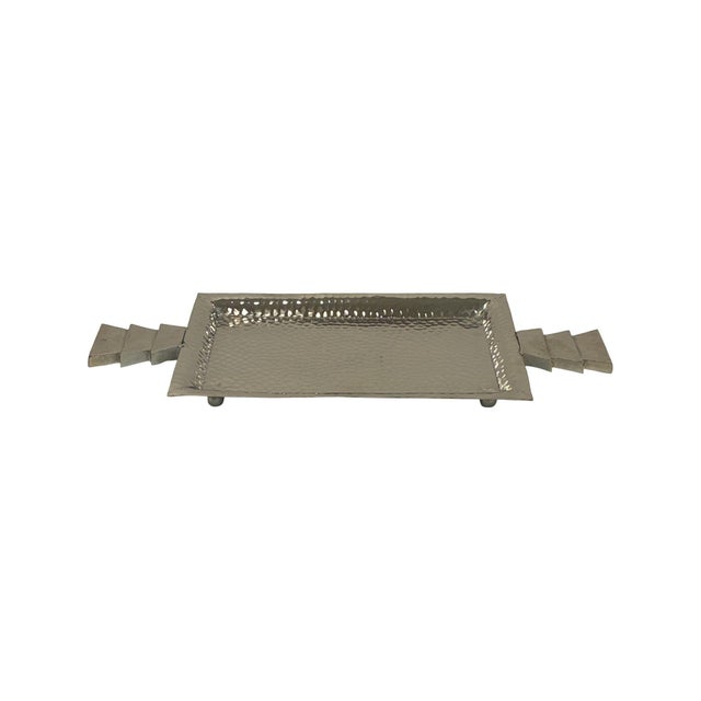 Featuring a rectangular hammered metal surface and distinctive stepped triangle handles, this tray brings texture, shine,...