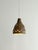 The compact bell-shaped body is heavily textured and covered in a deep earth-toned glaze with drips of brown, ochre and...