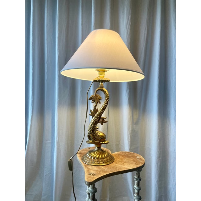 Large zoomorphic lamp, dolphin model, in bronze and gilt brass with a circular base. Produced in the 1950s-1960s in the...