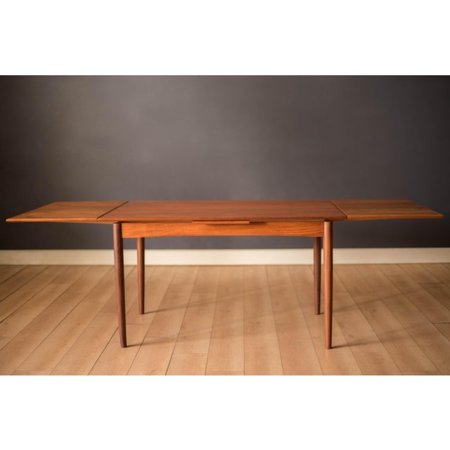 Mid century expanding dining table in teak circa 1960's. This simple and modern piece seats up to six comfortably...