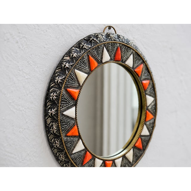 Handcrafted Moroccan round wall mirror with an ornate metal frame, orange and ivory bone inlay accents, and a vintage boho...