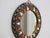 Handcrafted Moroccan round wall mirror with an ornate metal frame, orange and ivory bone inlay accents, and a vintage boho...