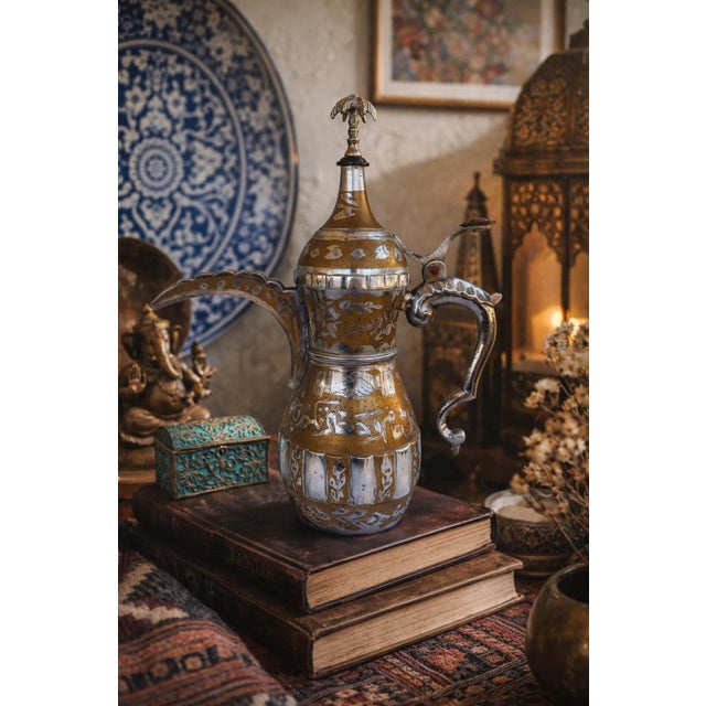 A beautifully detailed vintage Middle Eastern style Dallah coffee pot crafted in brass with silver-tone overlay and hand-...