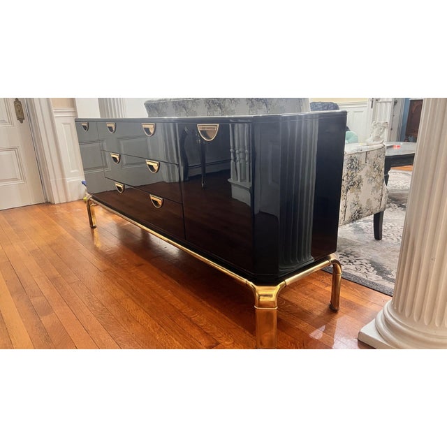 Discover the allure of this ultra-rare black lacquered credenza adorned with spectacular brass hardware and a brass base,...
