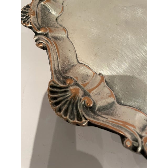 This is an English silver plated round barware/tableware serving tray with a lovely scallop shell design surround. The...