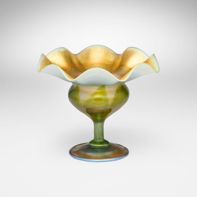 This exceptional Tiffany Studios pulled feather ruffled design Favrile glass vase, also known as a compote, was created by...
