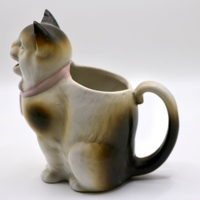 A delightful early 20th-century antique figural porcelain cat creamer jug crafted by the esteemed German pottery firm...