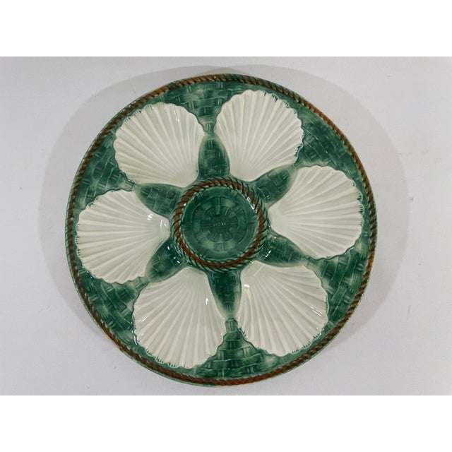 A beautiful classic French Longchamp glazed majolica oyster plate with a vibrant green faux basket weave background and...