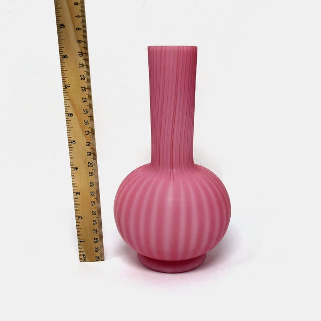 This antique Victorian velvet ribbed pink satin art glass vase is in good condition with some small chips as pictured.