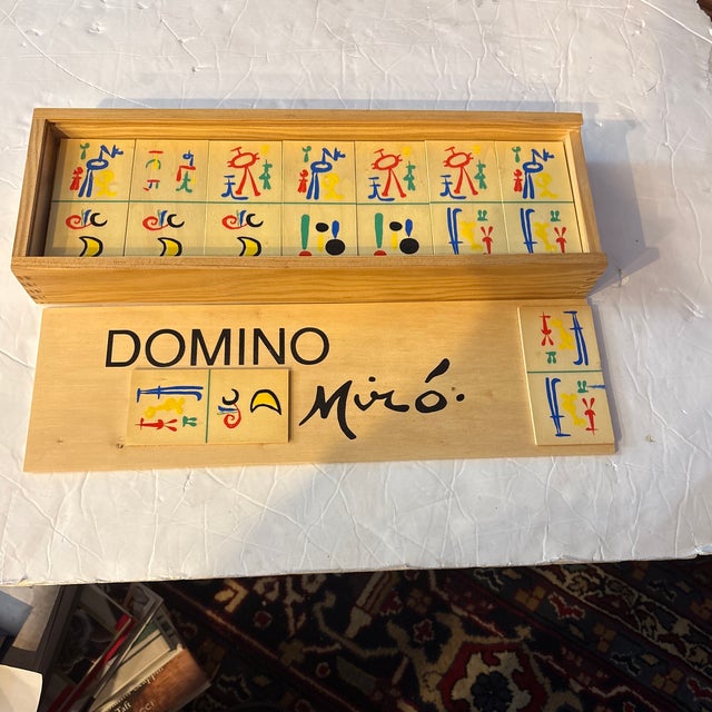 This image shows a vintage Joan Miró Domino set in a wooden box, likely produced around 1958 based on his "Parler Seul"...