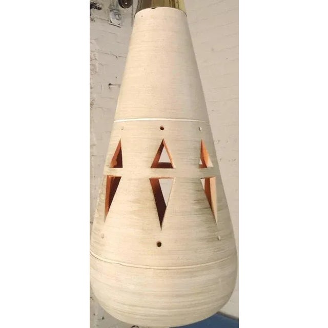 Narrow marble-top console with black steel base. Simple ceramic hanging pendant light with geometric cutouts. On/off...