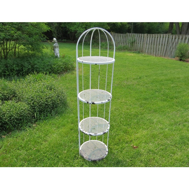 Vintage 1970's 4-tier round, dome top plant stand or shelving unit. The legs are solid iron ending on flat disc feet. Each...