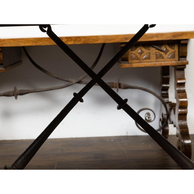 A French walnut console table from the 19th century, with trestle base and iron stretchers. Created in France during the...