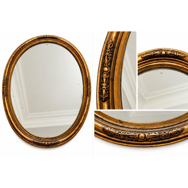 Vintage-style oval wall mirror by The Uttermost Company, featuring an ornate antique gold-tone frame with decorative...