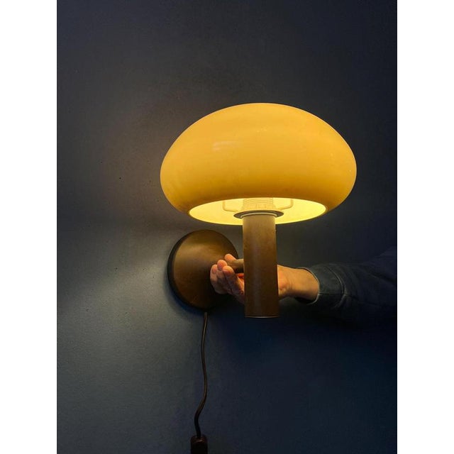 Small vintage space age mushroom wall lamp by Massive. The frame is made of metal and has a brown lacquer. The beige/brown...