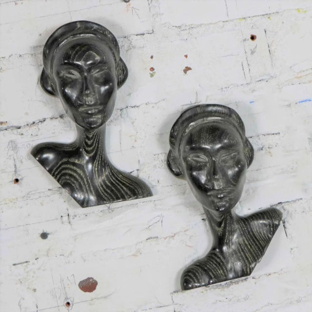 Incredible pair of Mid Century Modern to Art Deco style carved ebonized oak female bust wall hung sculptures. They are in...