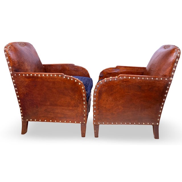 It is my pleasure to present an exceptional pair of early French leather club chairs. These charming armchairs are adorned...