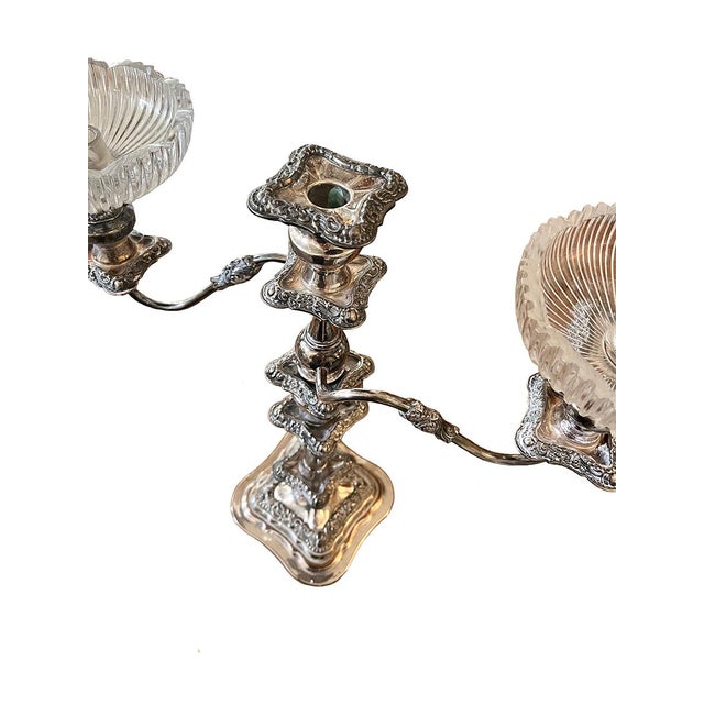 This stunning candlestick holds three candles. It features two arms, each topped with a glass bobeche. There is botanical...