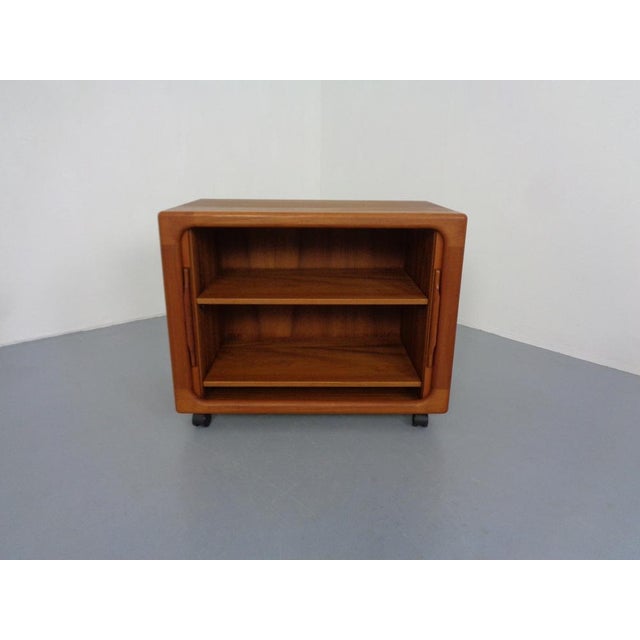 Small, rollable sideboard from Dyrlund in teak. Two pull-out shelves. I have official proof of authenticity such as...