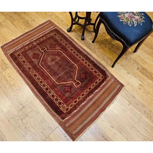 An exquisite early 20th-century Baluch tribal area rug, crafted with exceptional detail and artistry. This antique rug...