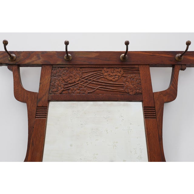 A handsome Belgian Art Nouveau wall-mounted coat rack dating from the early 20th century, crafted in solid oak and...