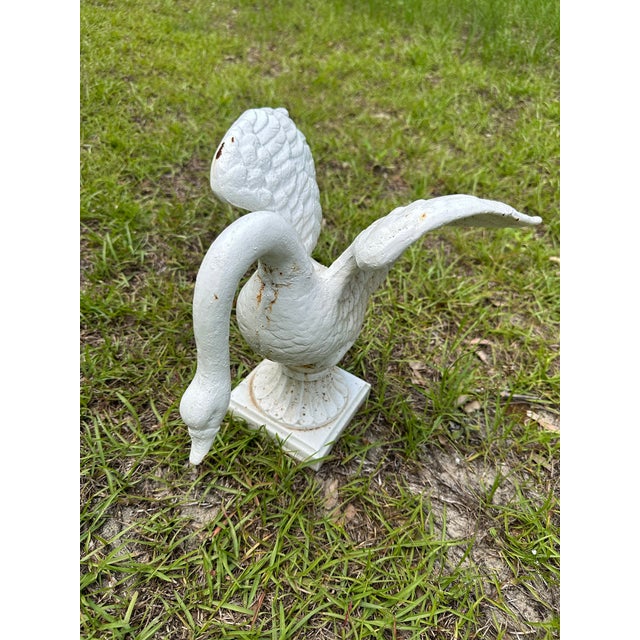 A charming pair of vintage cast iron swan garden ornaments, beautifully modeled with gracefully curved necks and...