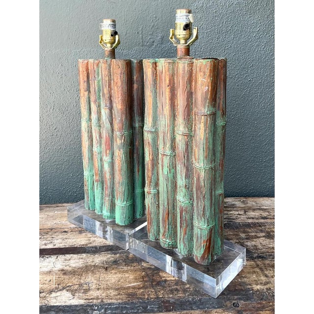 Exuding sophisticated Hollywood Regency charm, this pair of vintage Mid-Century table lamps features sculptural faux...