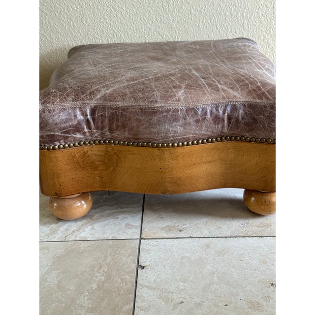 Western style distressed leather ottoman with nailhead trim on a solid maple base with bun feet. Taupe leather, scalloped...