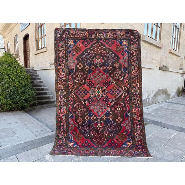 This is a vintage Kurdish Herki tribal rug, hand-knotted with wool and about 50 years old. It shows strong geometric...