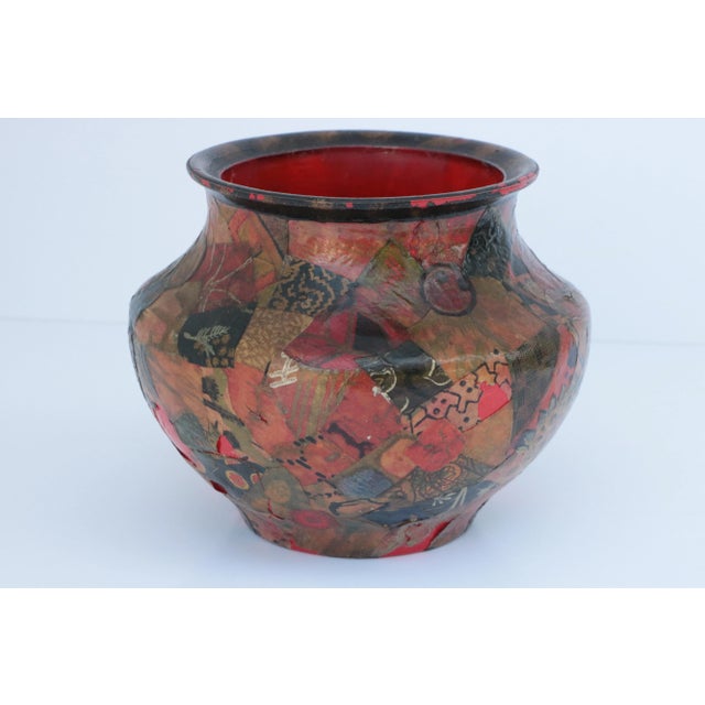 Covered with carefully cut paper scraps, this painted collage vase is cherry red with a black and gold rim. Signed and...