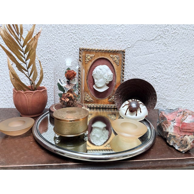 Vintage round plateau mirror with a beveled glass surface set in a chrome metal frame. Supported by four rounded feet,...