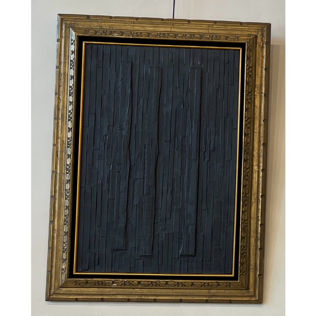 Textured black abstract artwork with vertical relief detailing, set in an ornate antique gilt wood frame. Deep matte black...