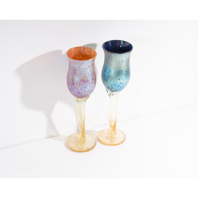 A pair of art glass wine/goblet glasses by American artist Aaron Slater. One glass is pink and one blue with yellow twist...