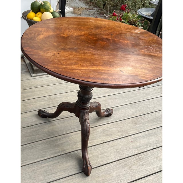 Magnificent mahogany tilt top tea table ascribed to the Salem Massachusetts area. The stepped edge 1 board top showcases a...