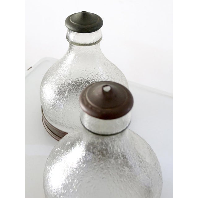 This pair of vintage warehouse light shades dates to the 1930s and features clear patterned glass bodies with metal base...