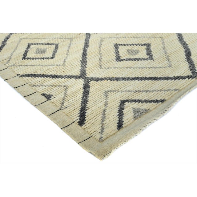Discover the elegance of this contemporary Moroccan handcrafted wool rug, featuring a striking geometric design in a...