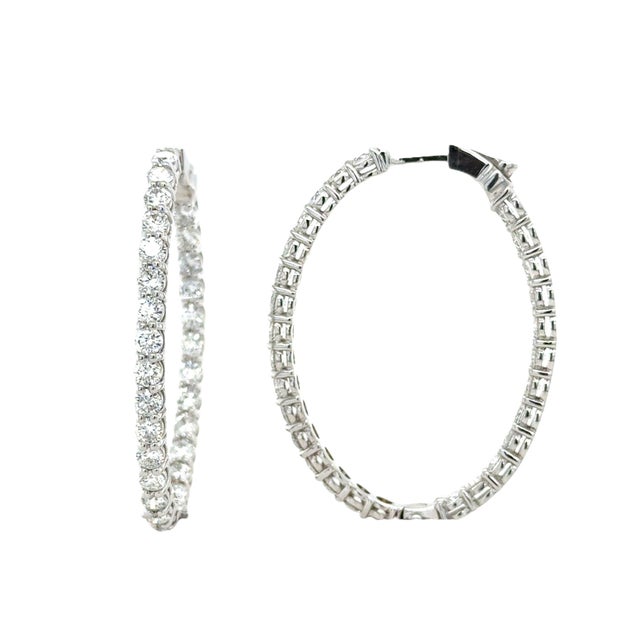 In a sleek and modern design, these hoop earrings contain 56 round brilliant cut diamonds weighing 6.00 carat total, in an...